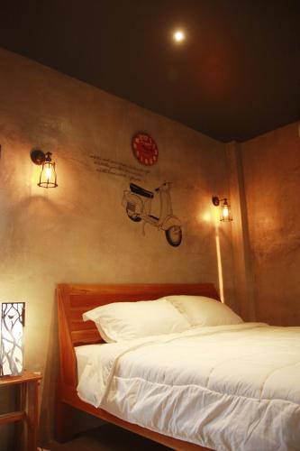 a bedroom with a bed with a motorcycle on the wall at The Sunnery Ville in Lom Kao