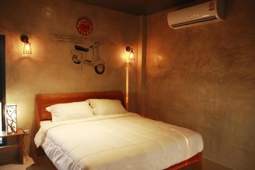 a bedroom with a bed and a motorcycle on the wall at The Sunnery Ville in Lom Kao