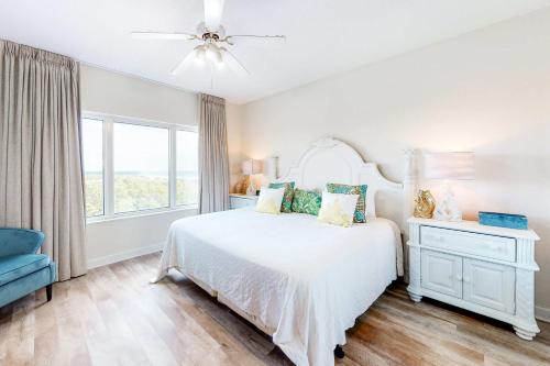 a white bedroom with a bed and a window at TOPS'L Summit II in Destin