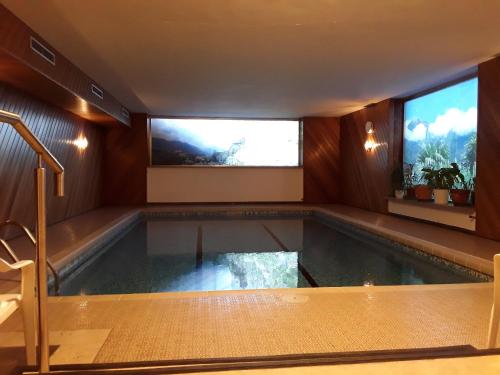 a swimming pool in a house with two windows at Hotel Haselried in Tirolo