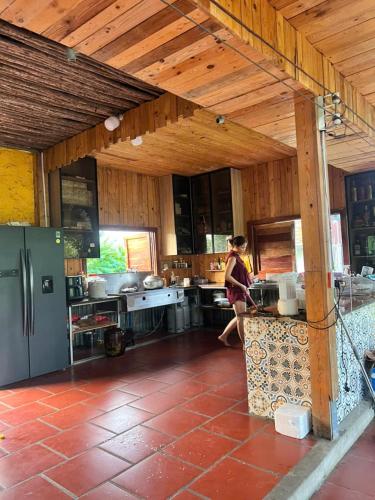 a woman walking through a kitchen in a house at Homestay GETA House in Ấp Thanh Sơn (1)