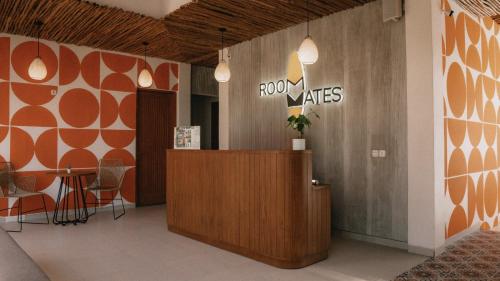 a lobby with a reception desk and a row of chairs at Roomates Beach Hostel Canggu by Ini Vie Hospitality in Canggu