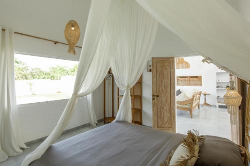 a bedroom with a bed with a canopy at Uluwatu - Beach Villa 5 in Uluwatu