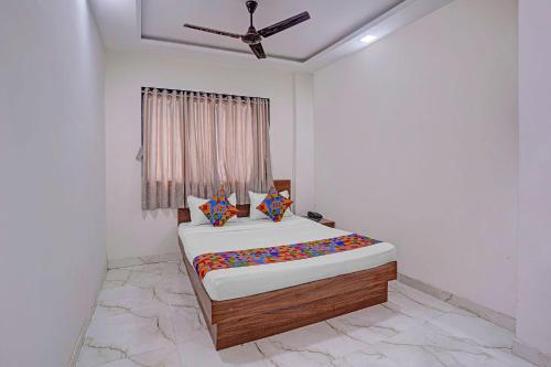 a bedroom with a bed and a ceiling fan at FabHotel Red Rose Palghar in Nale Sopāra