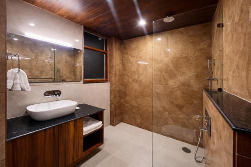 a bathroom with a sink and a shower at Avasa Boutique Hotel Manali in Manāli