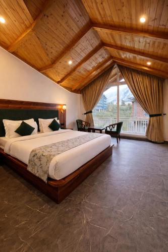 a bedroom with a large bed and a large window at Avasa Boutique Hotel Manali in Manāli
