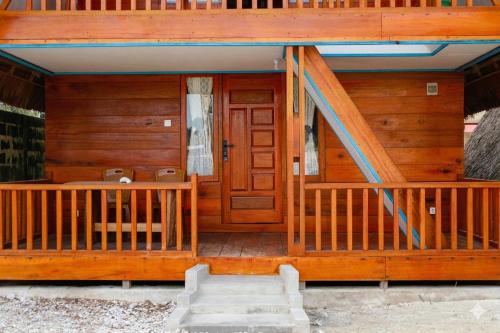 a front porch of a log cabin with a wooden door at Baruk Homestay in Katiet