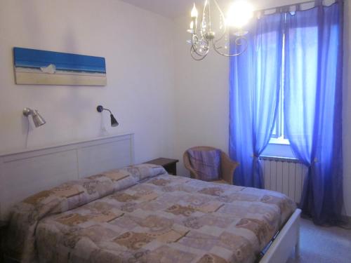 a bedroom with a bed and a window with blue curtains at Cà di Boschetti Old Farm f in La Spezia