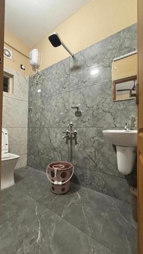 a bathroom with a shower and a toilet and a sink at New Castle Residency in Cochin