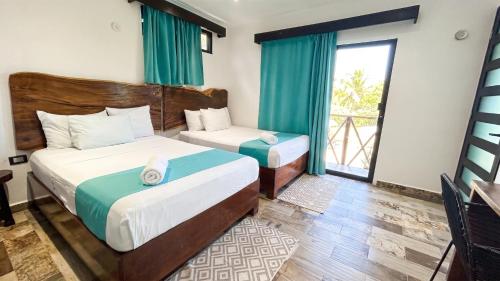 a bedroom with two beds and a window at Hotel y Beach Club Casa Mia Xulha -Bacalar in Xul-Ha