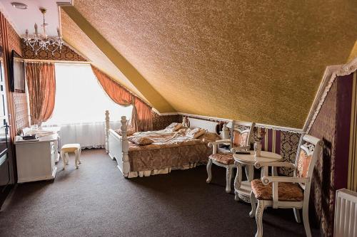 a bedroom with a bed and a table and chairs at Golden Palace in Dubove
