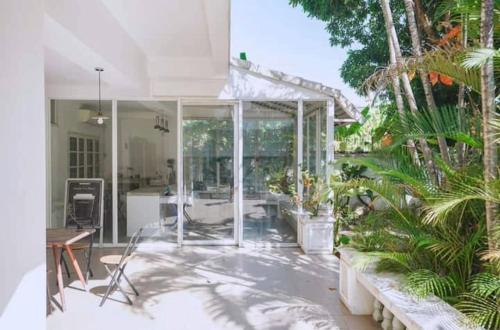 a white house with a patio with palm trees at DoubleTree House in Chiang Mai