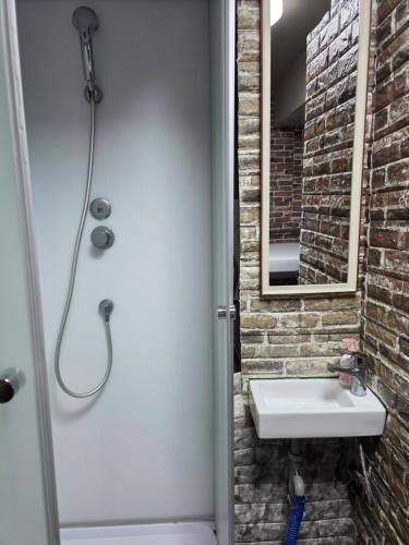a bathroom with a sink and a brick wall at Sophiearth Apartment in Tokyo