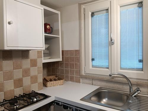 a kitchen with a sink and two windows at Liberty 21 in Andria