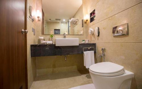 a bathroom with a white toilet and a sink at The Residency Towers Coimbatore in Coimbatore