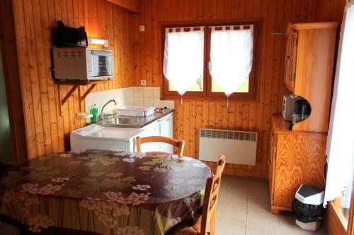 a small kitchen with a table and a sink at Chalet Thérence à Mesples in Mesples