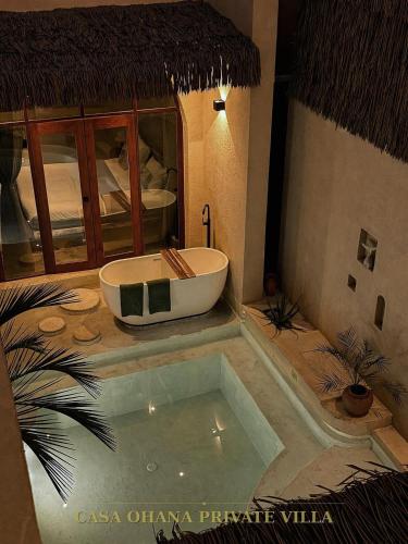 a bathroom with a bath tub in a room at CASA Ohana Private Villa in Thai Muang