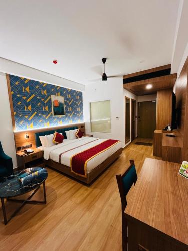 a hotel room with a bed and a table and a table sidx sidx at Celestial International in Taliparamba