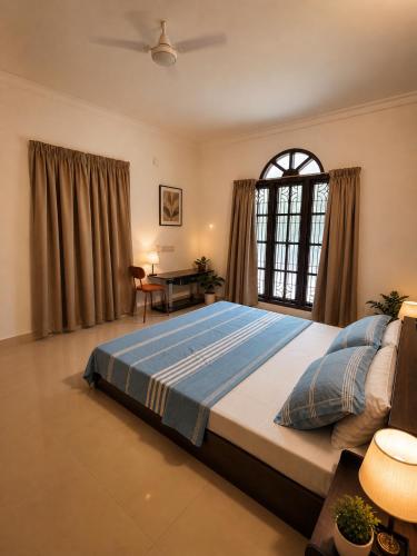 a bedroom with a large bed and a table at Aurena Stays Varkala in Varkala