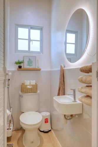 a bathroom with a toilet and a sink and a mirror at 3BR Guesthouse near Panglao - Pool Access - Bohol Tours - Fast WiFi in Dauis