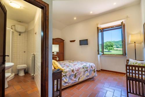 a bedroom with a bed and a bathroom at Agriturismo Il Cavallino Saturnia in Semproniano