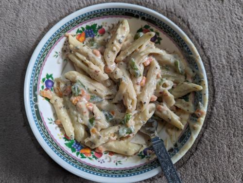 a plate of pasta on a table with a fork at Mochilero Eyrie in Kaza