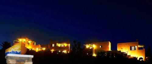a group of buildings lit up at night at Onar Studios in Koufonisia