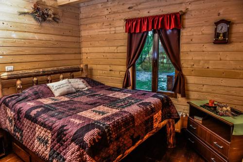 a bedroom with a bed in a log cabin at The Little Mountain Cabin in Borlova