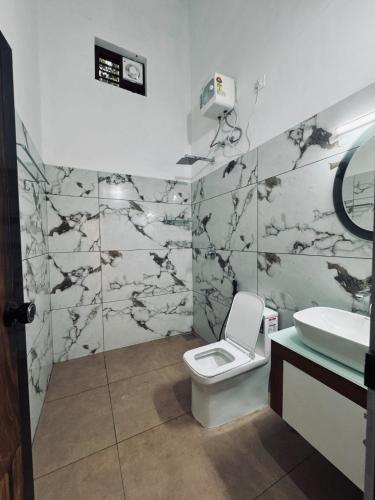 a bathroom with a toilet and a sink at Chills homestay in Kalpetta
