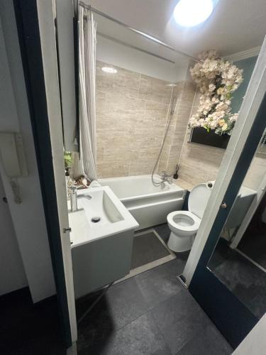 a bathroom with a sink and a toilet and a bath tub at Charming Flat in North London in Edmonton