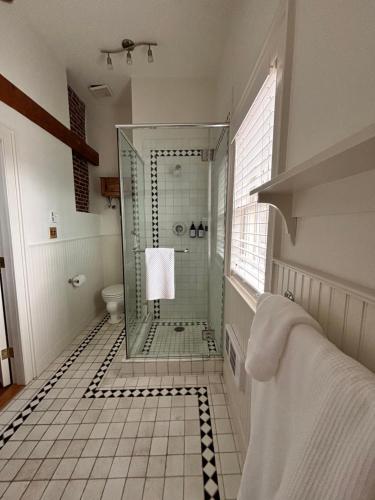 a bathroom with a glass shower and a toilet at Windsor House Inn in Saint Andrews