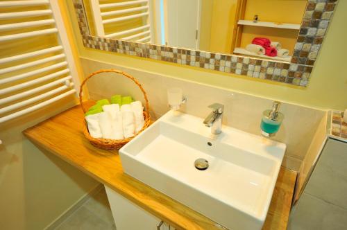 a bathroom with a sink and a basket of towels at Apartment Sovica in Belgrade