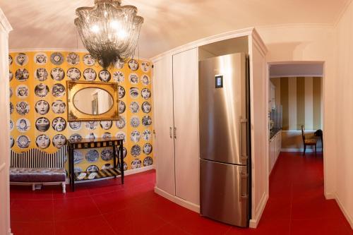 a kitchen with a refrigerator and a wall of plates at Kyiv Yuriya Ilyenko street new building close to the downtown in Kyiv