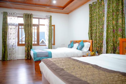 a hotel room with two beds and a window at The Other House Srinagar in Srinagar