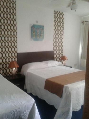 a hotel room with two beds and two lamps at Complejo Turistico Anaconda Hotel in La Paloma
