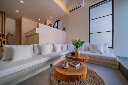 a living room with a white couch and a table at 2BR villa w- pool & beach access in Mengwi