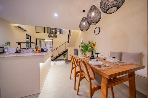 a kitchen and dining room with a wooden table and chairs at 2BR villa w- pool & beach access in Mengwi