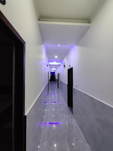 a long hallway with purple lights on the floor at Heaven Heights in Rājpur