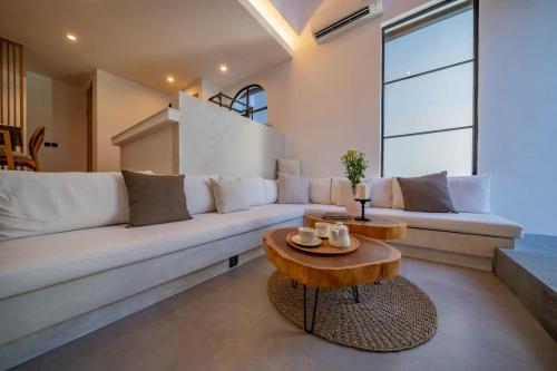 a living room with a white couch and a table at Breezy villa w- pool & beach access in Mengwi