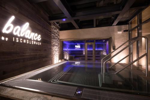 a hot tub in a building with a sign on the wall at Alpenhotel Ischglerhof in Ischgl