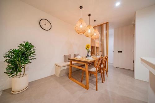 a dining room with a table and a clock on the wall at Breezy villa w- pool & beach access in Mengwi