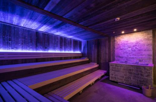 a sauna with purple lights on a brick wall at Alpenhotel Ischglerhof in Ischgl