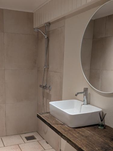 a bathroom with a sink and a mirror at Ørsted Outdoor in Lille Ladager