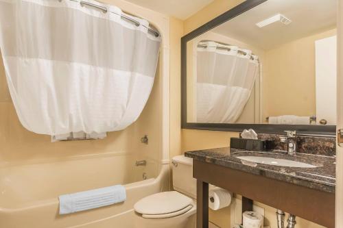 a bathroom with a sink and a toilet and a mirror at Comfort Inn Cobourg - Port Hope in Cobourg