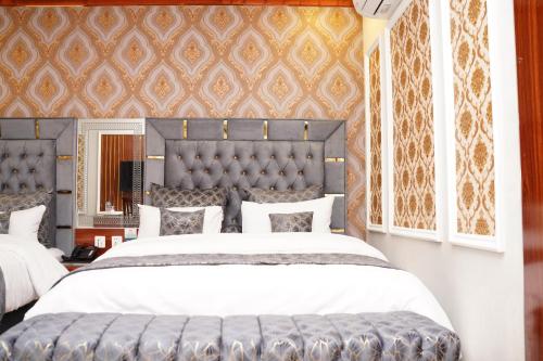 a bedroom with a large bed with a large headboard at Hotel Grand Orchard in Lahore