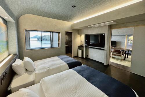 a hotel room with two beds and a television at Kochoran in Toba