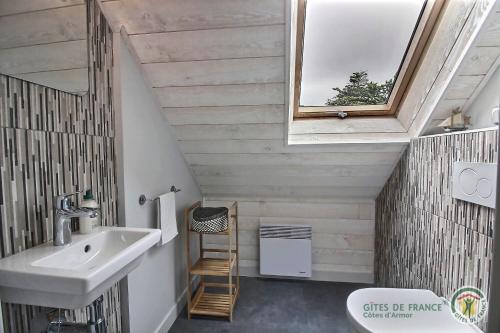 ein Badezimmer mit Waschbecken und Spiegel in der Unterkunft Les flots in Binic