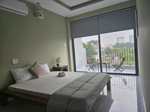 a bedroom with a bed and a large window with a patio at Bống's Homesray and café in Ho Chi Minh City