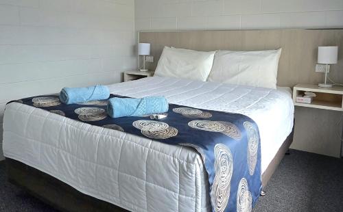 a bedroom with a large bed with two pillows on it at Albatross Motel in Lakes Entrance