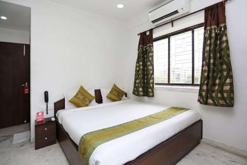 a bedroom with a large bed with a window at Star Spandan in New Town